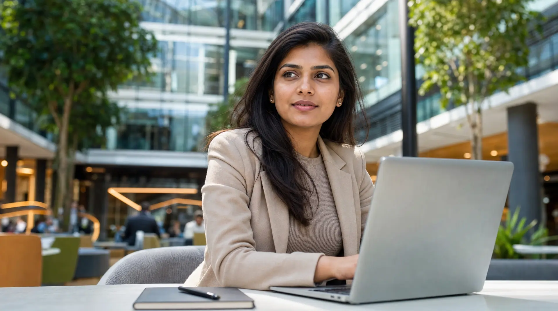 Professional in an atrium office reviewing compliance ai workflows on a laptop, supporting corporate compliance.
