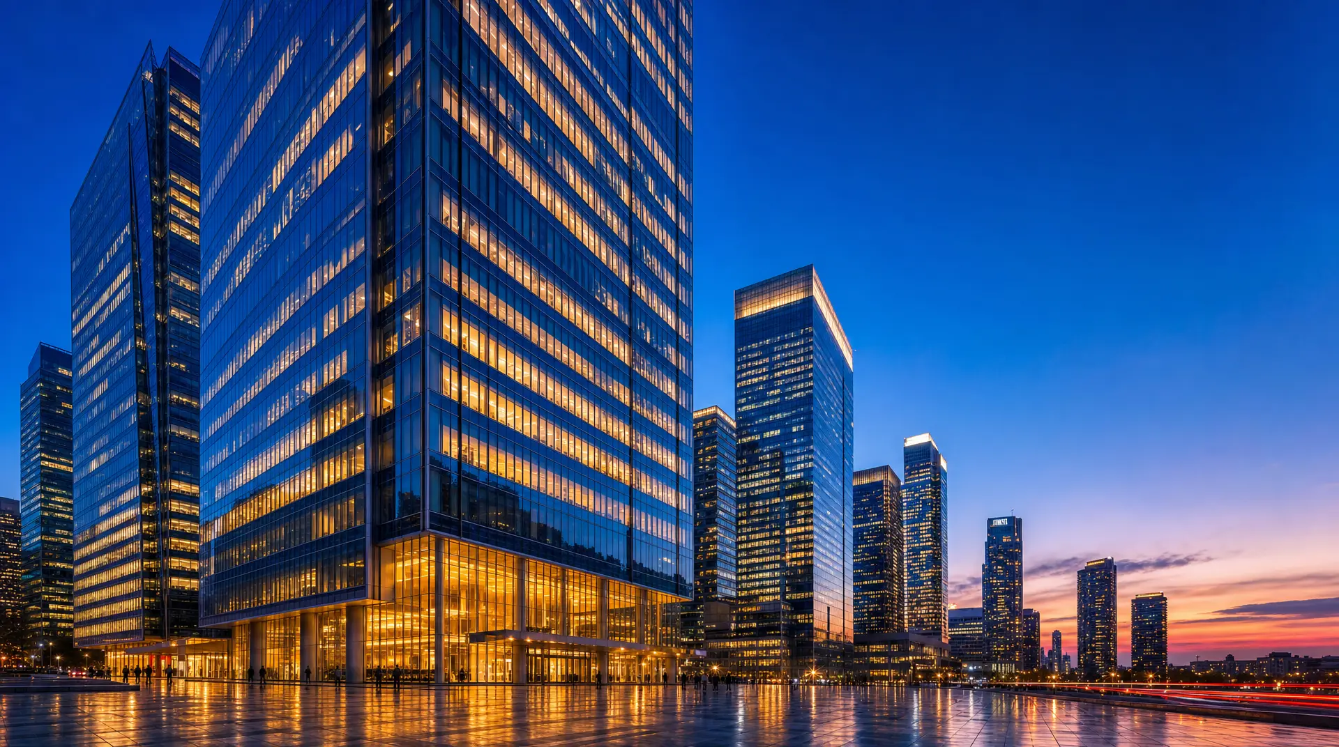 Twilight skyline of glass office towers, signaling global expansion and corporate compliance readiness.